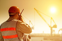 worker with large crane site and sunset background